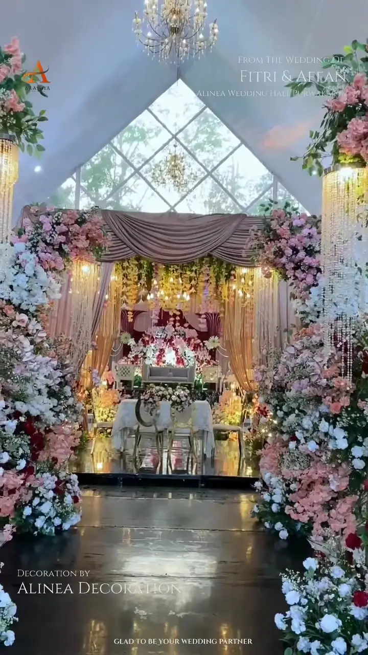 Pelaminan berhias bunga merah muda di dalam Alinea Wedding Hall yang beratap kaca