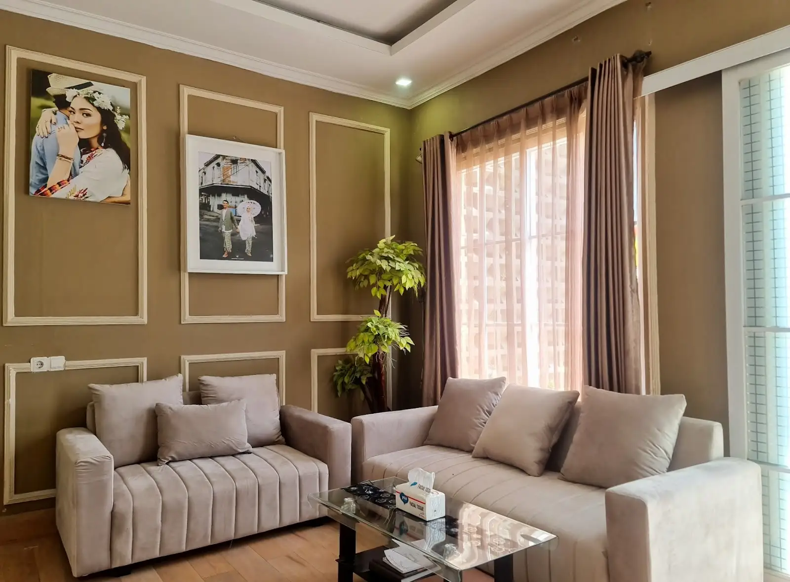 Ruang tamu kantor Alinea dengan sofa krem dan dinding berpanel