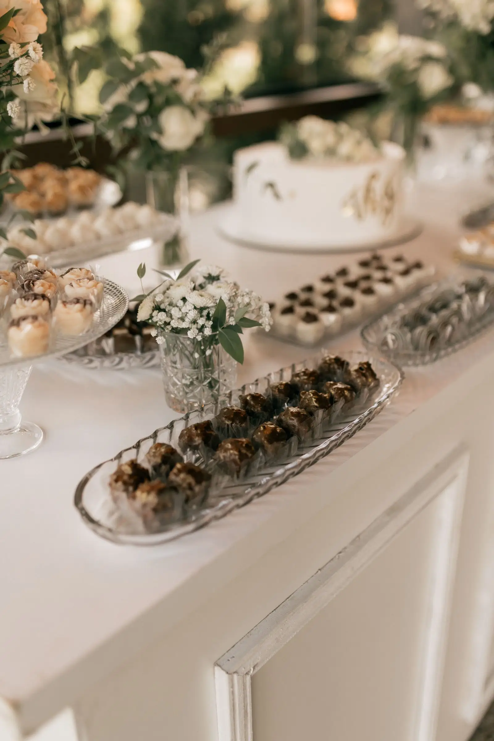 Meja dessert dengan kue pengantin putih dan aneka kue kecil (foto ilustrasi).